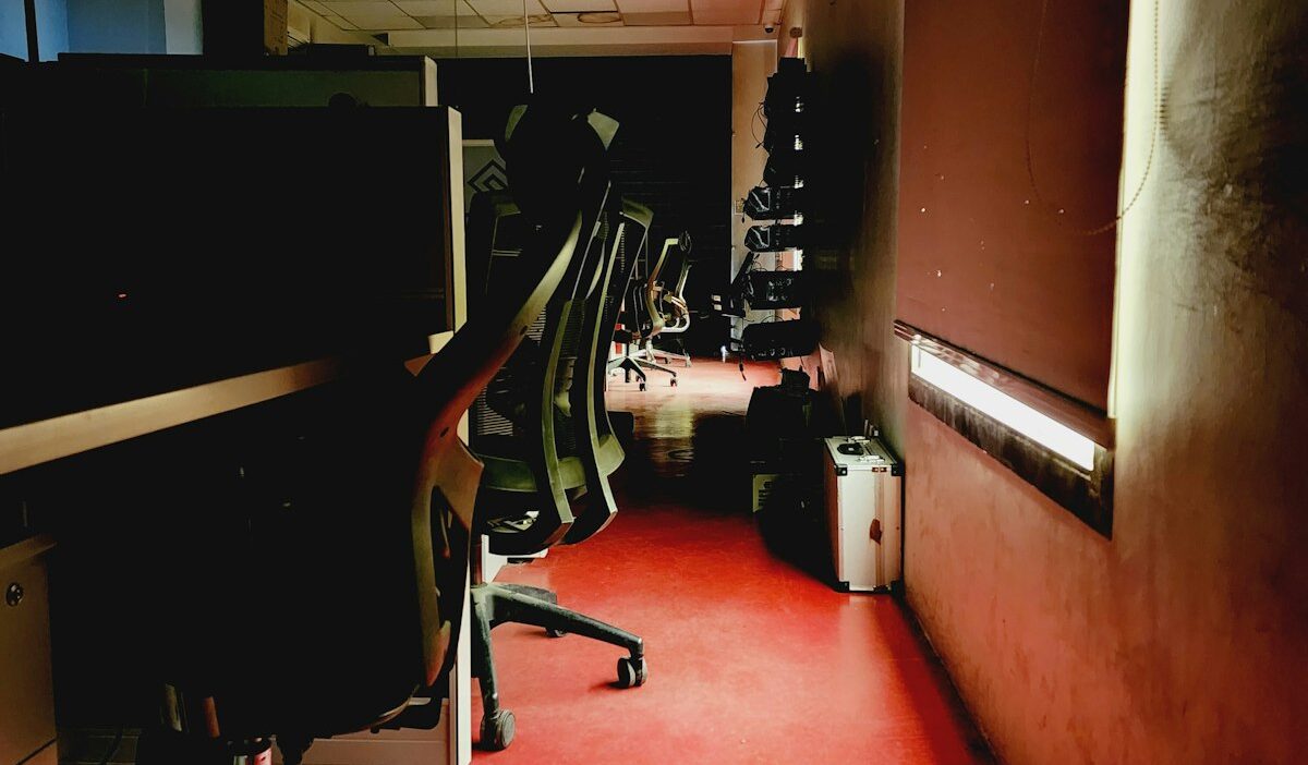 Empty publisher newsroom with dark computer screens symbolizing Mediavine layoffs and AI search traffic collapse in ad tech industry