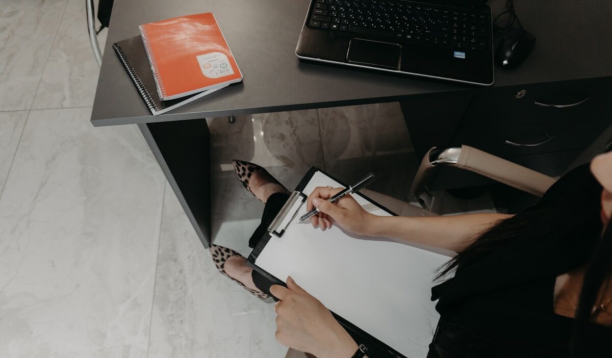 Marketer shredding excess data while checking state-by-state privacy compliance checklist on desk with laptop and coffee