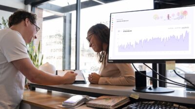 Advertising professionals studying data on a computer screen to measure campaign performance and optimize marketing strategies.
